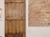 Vista frontale porta antica rustica montata come scorrevole
